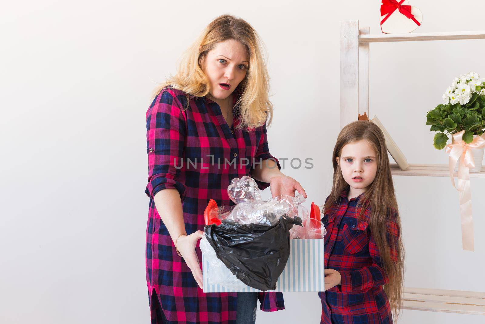 Environmental protection and pollution concept. Surprised woman holds box with plastic trash