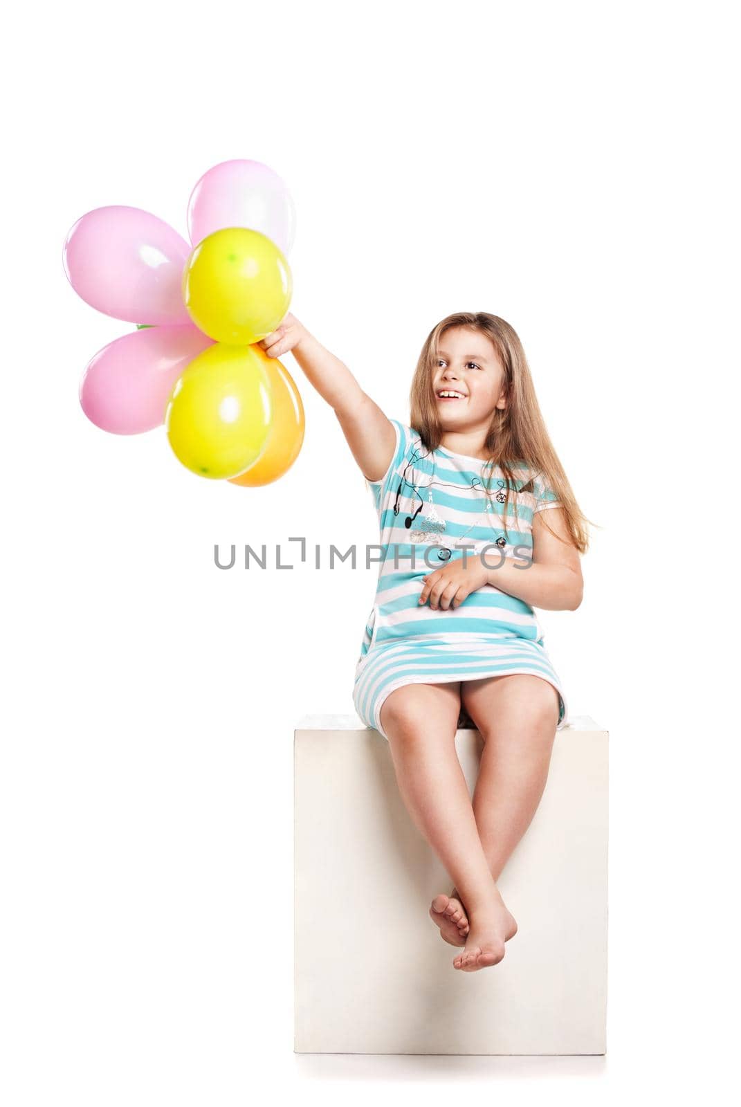 Little girl playing with colourful balloons on a white background