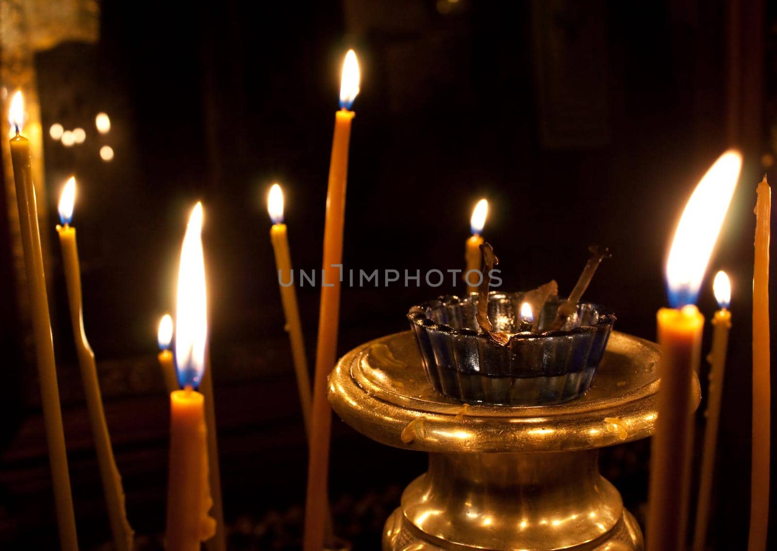 photo of burning candles in church with dark background