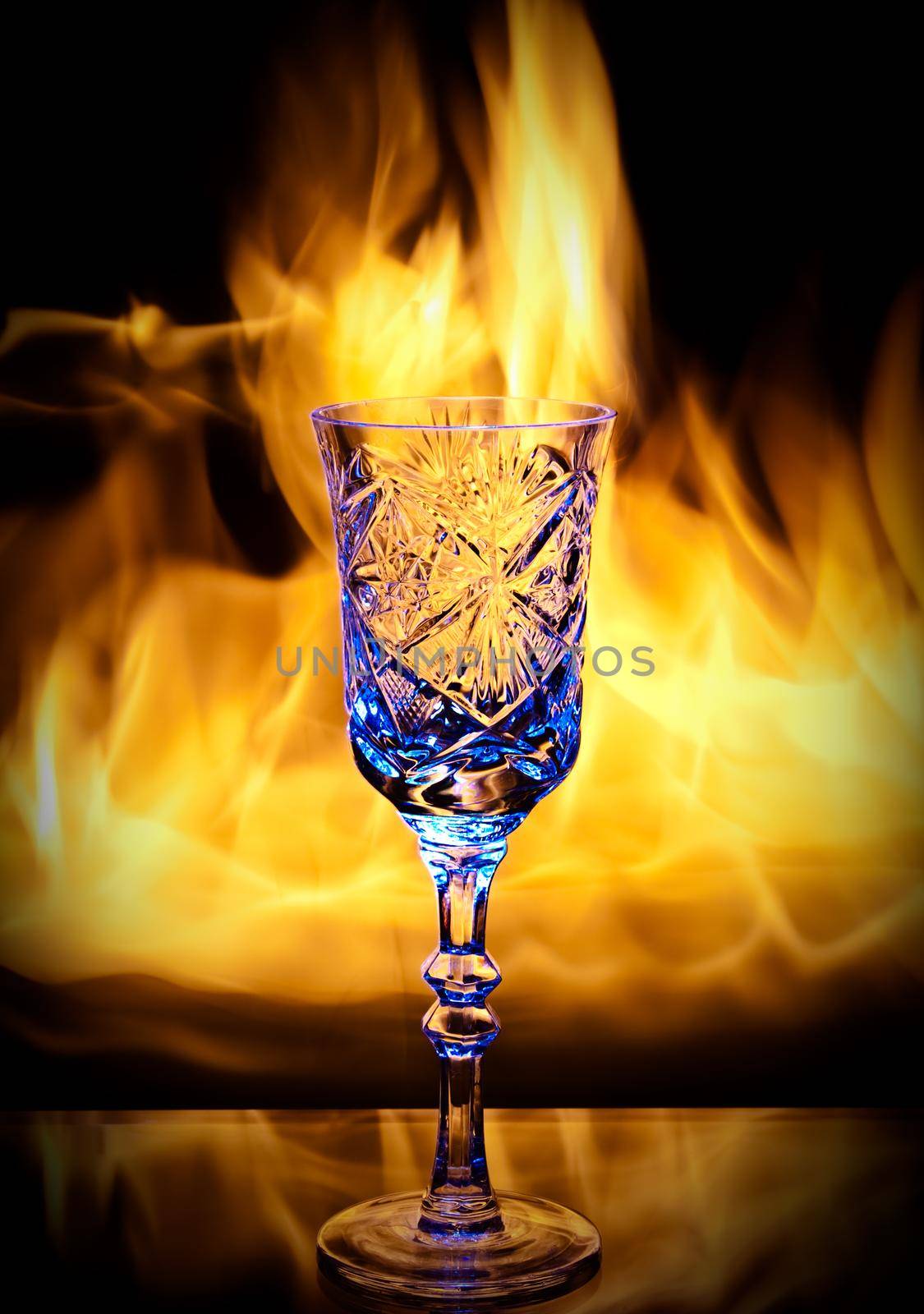 photo of the goblet with blue tint of water on real fire background