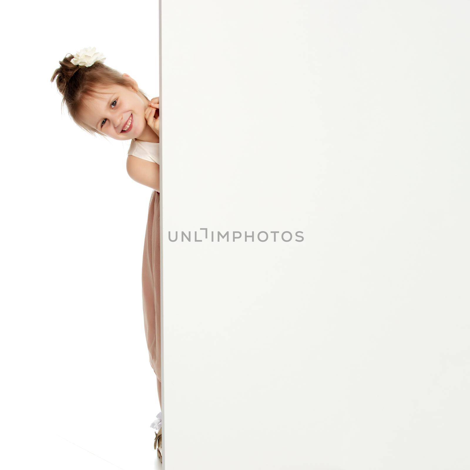 Cute little girl peeking out from behind the white banner.Isolated on white background.