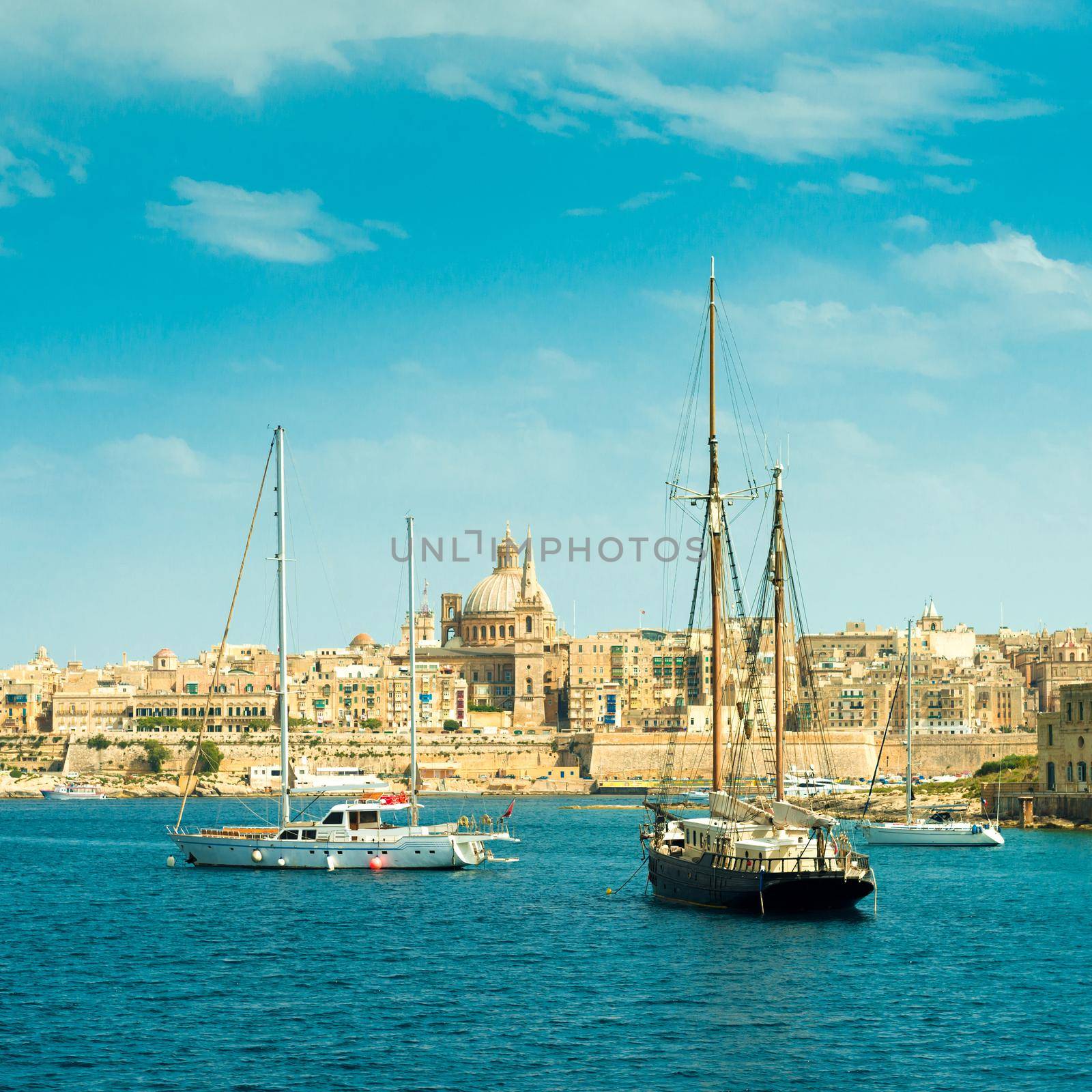 picturesque view of sailing boats with Valletta cityscape on the background, Malta