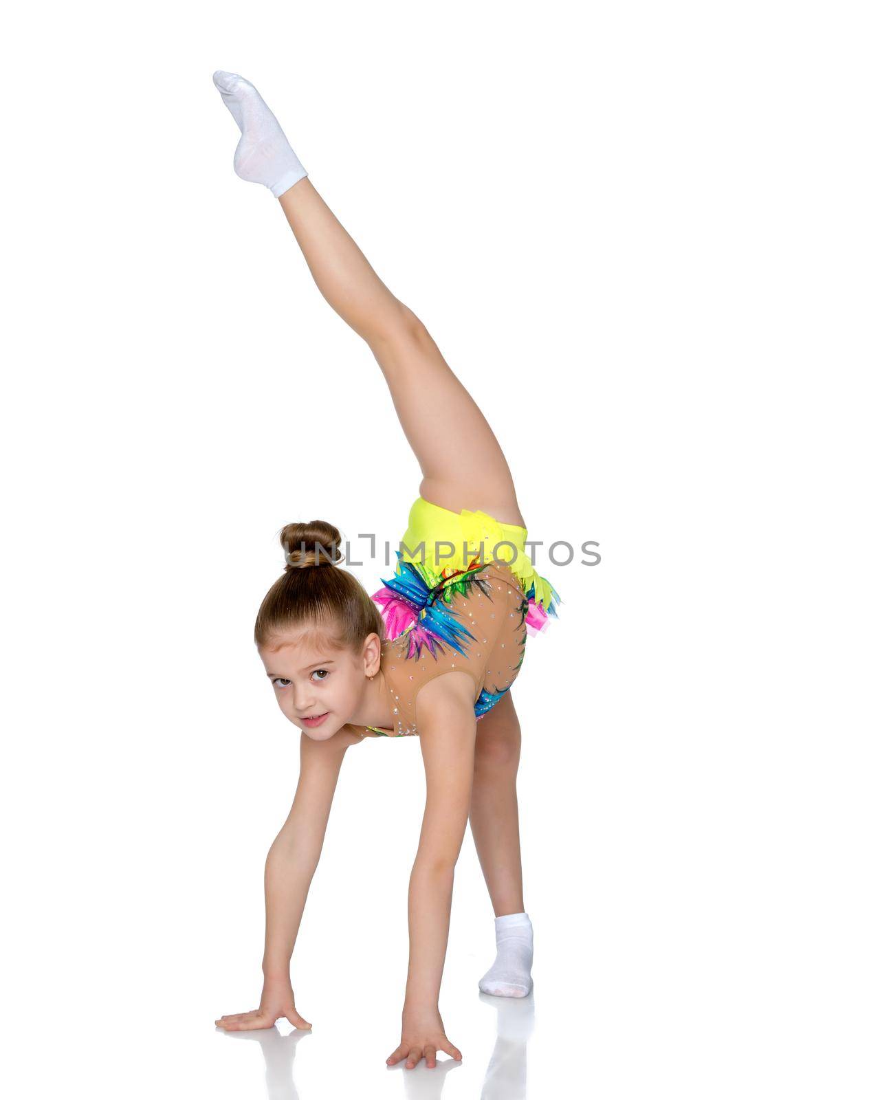 A girl gymnast balances on one leg.The concept of childhood, sport, a healthy lifestyle. Isolated on white background.