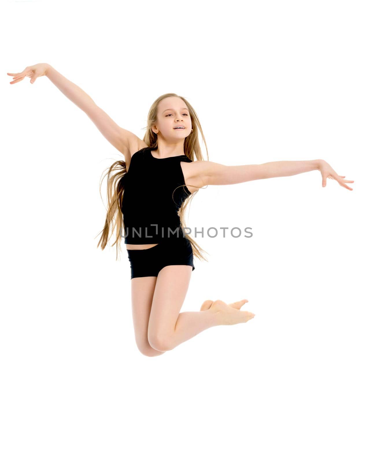 A little girl gymnast joyfully jumps and wags her hands. The concept of sport and fitness. Isolated over white background