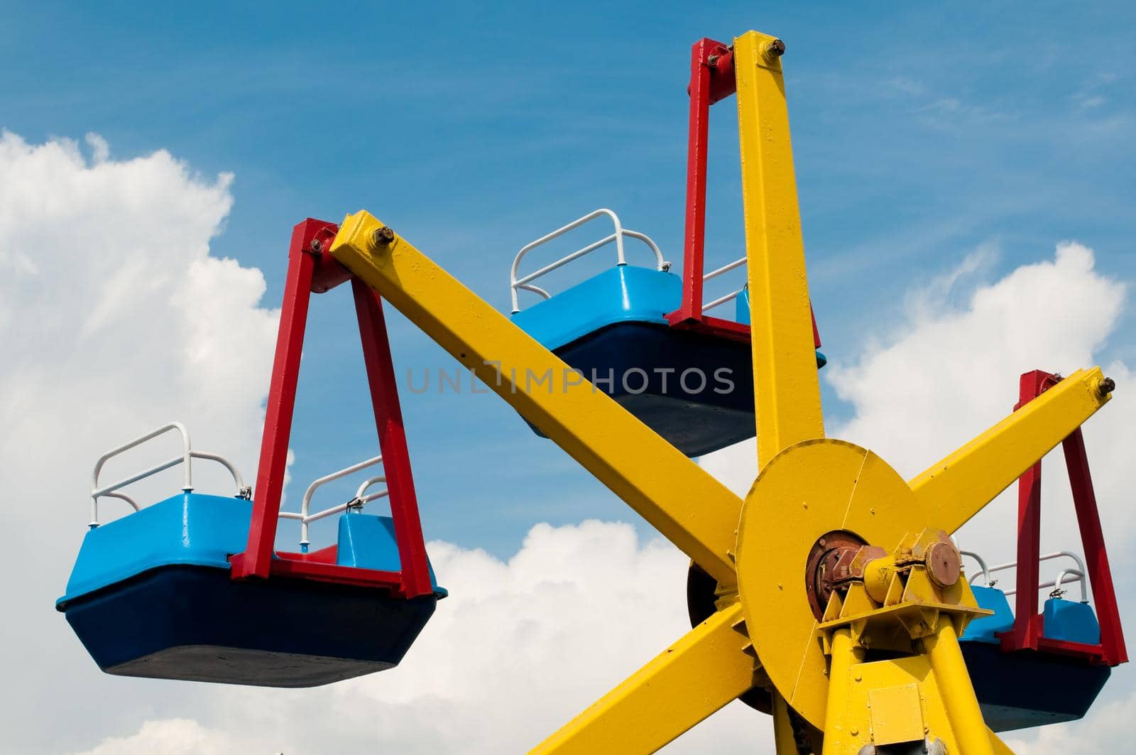 colorful carousel in theme park with summer blue cloudy sky in background