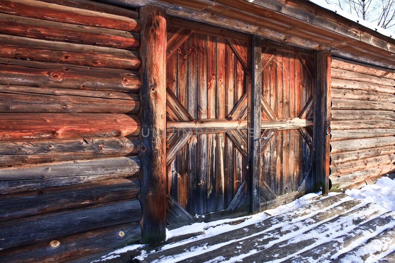 wooden farm barn house with closed door in winter