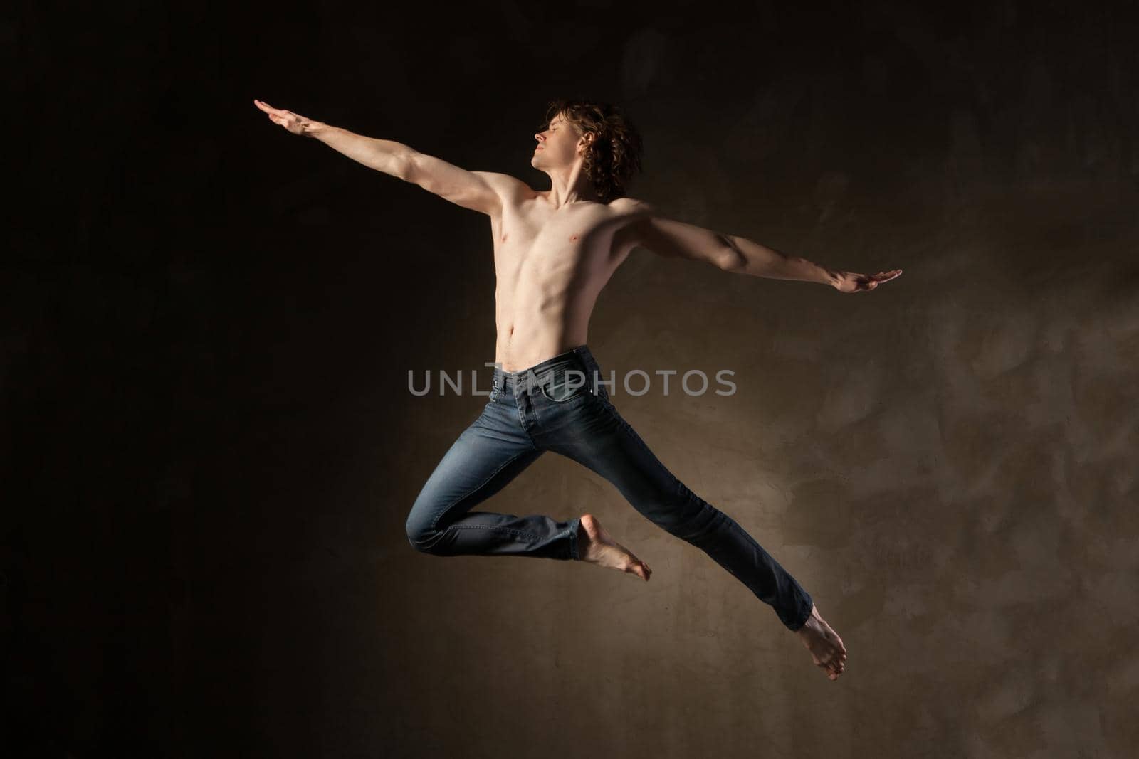 Young and stylish modern dancer on grey grunge background