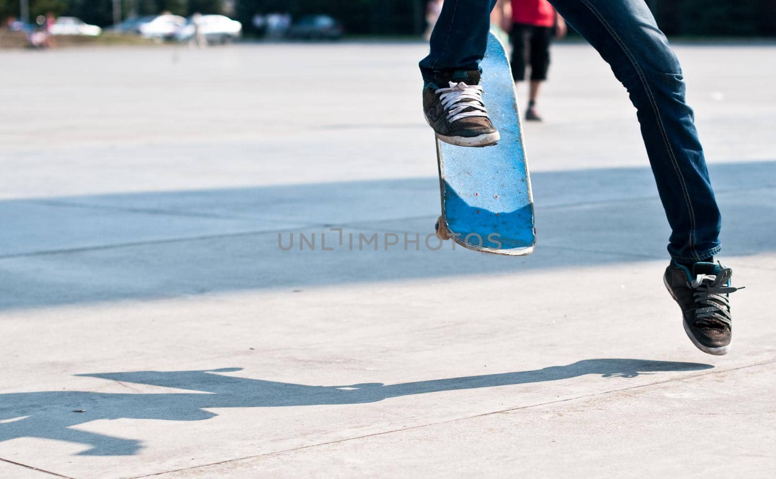 young skater perfoming stunt on his blue board