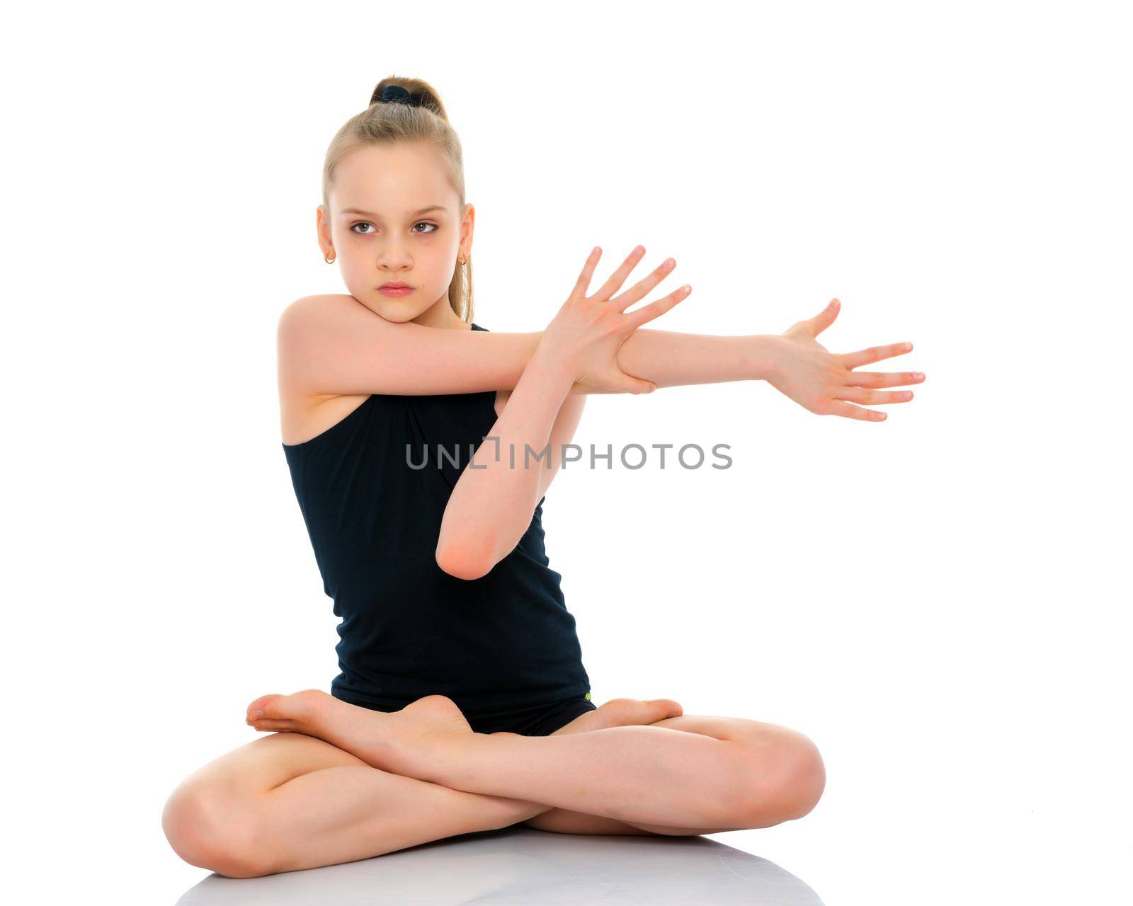 A nice little girl sits in a lotus position and meditates. Concept of yoga, happy people. Isolated on white background.