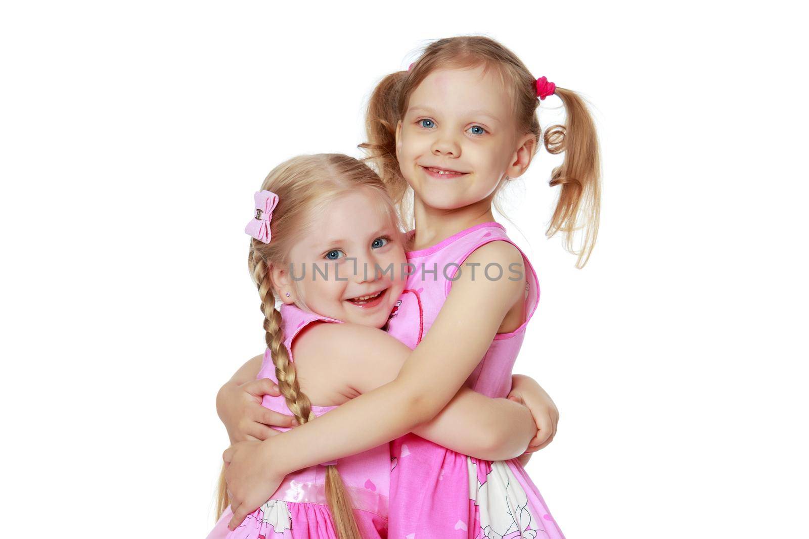Two cute little girls close-up, in the studio on a white background. The concept of a happy childhood, Beauty and fashion. Isolated.