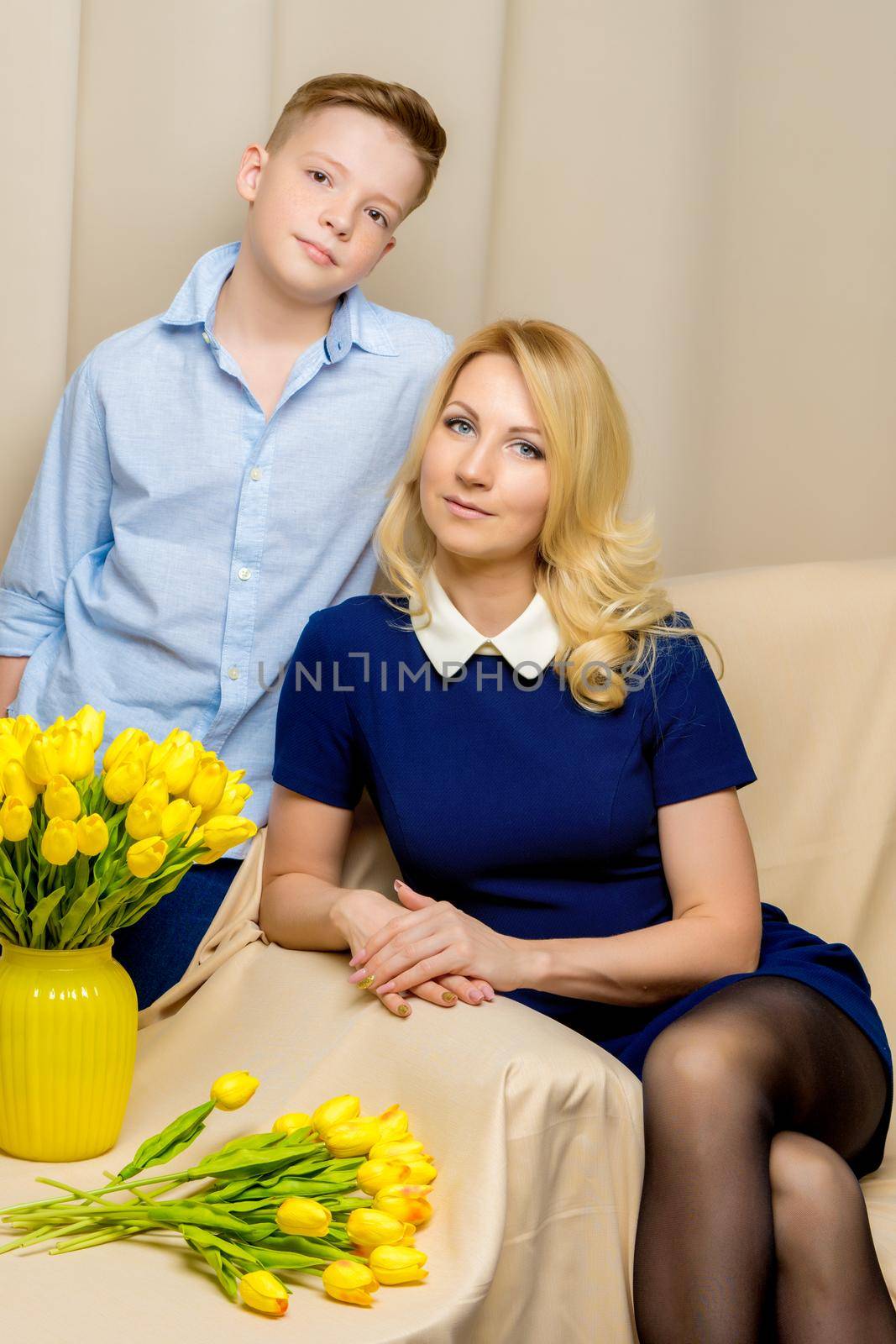 Happy young mother and her son near a bouquet of tulips. by kolesnikov_studio