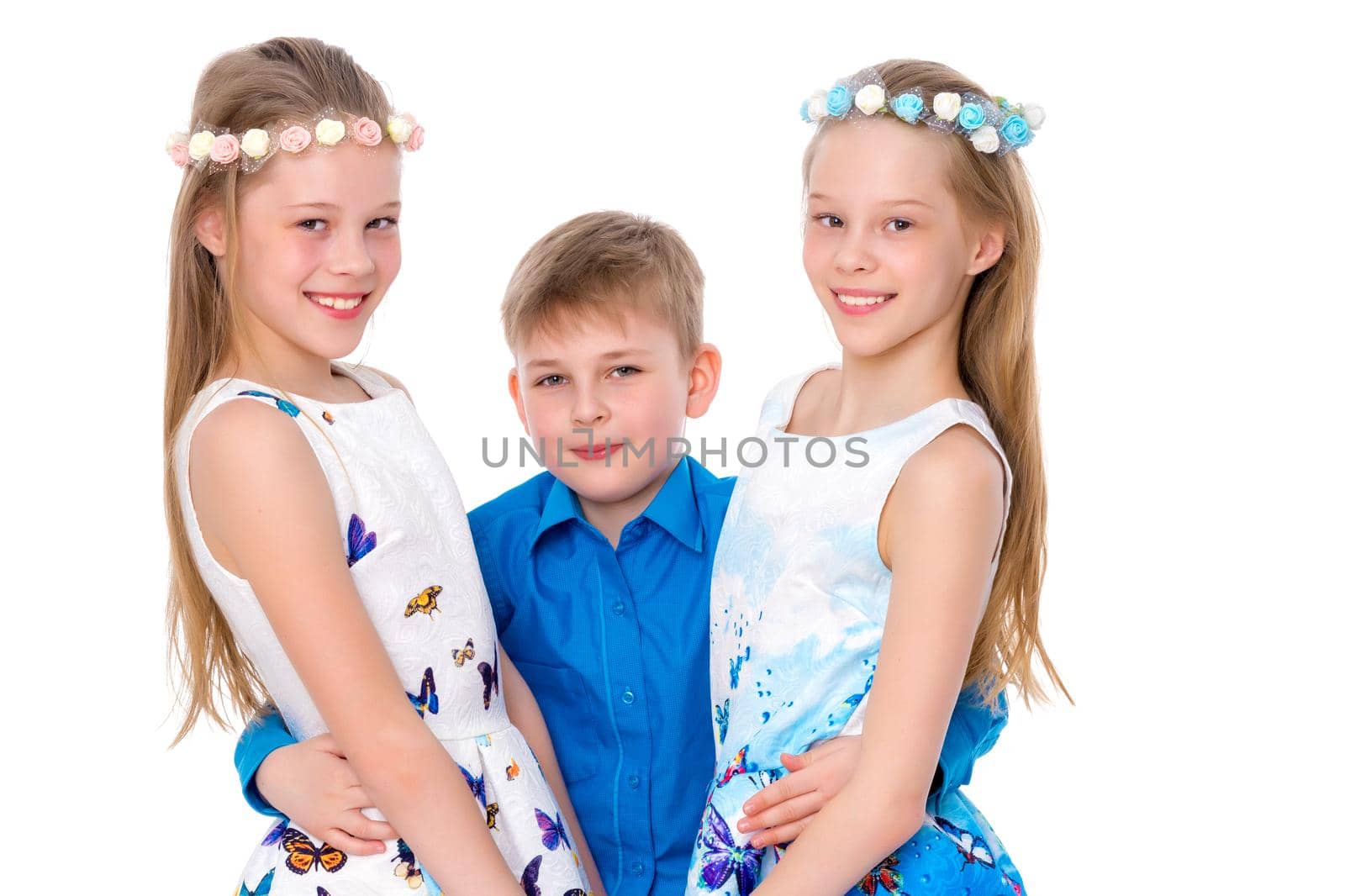 The cheerful girls are gymnasts, and the little boy of their brother hugs together. The concept of fitness and sports, a happy childhood. Isolated on white background.