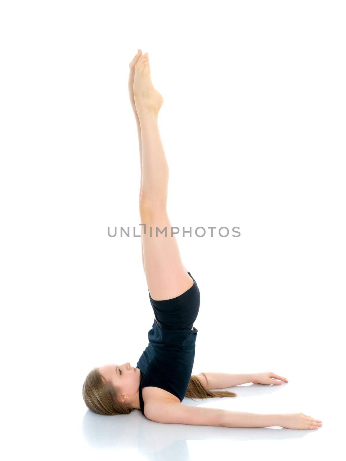 A girl gymnast performs an acrobatic element on the floor. The concept of childhood, sport, healthy lifestyle. Isolated on white background.