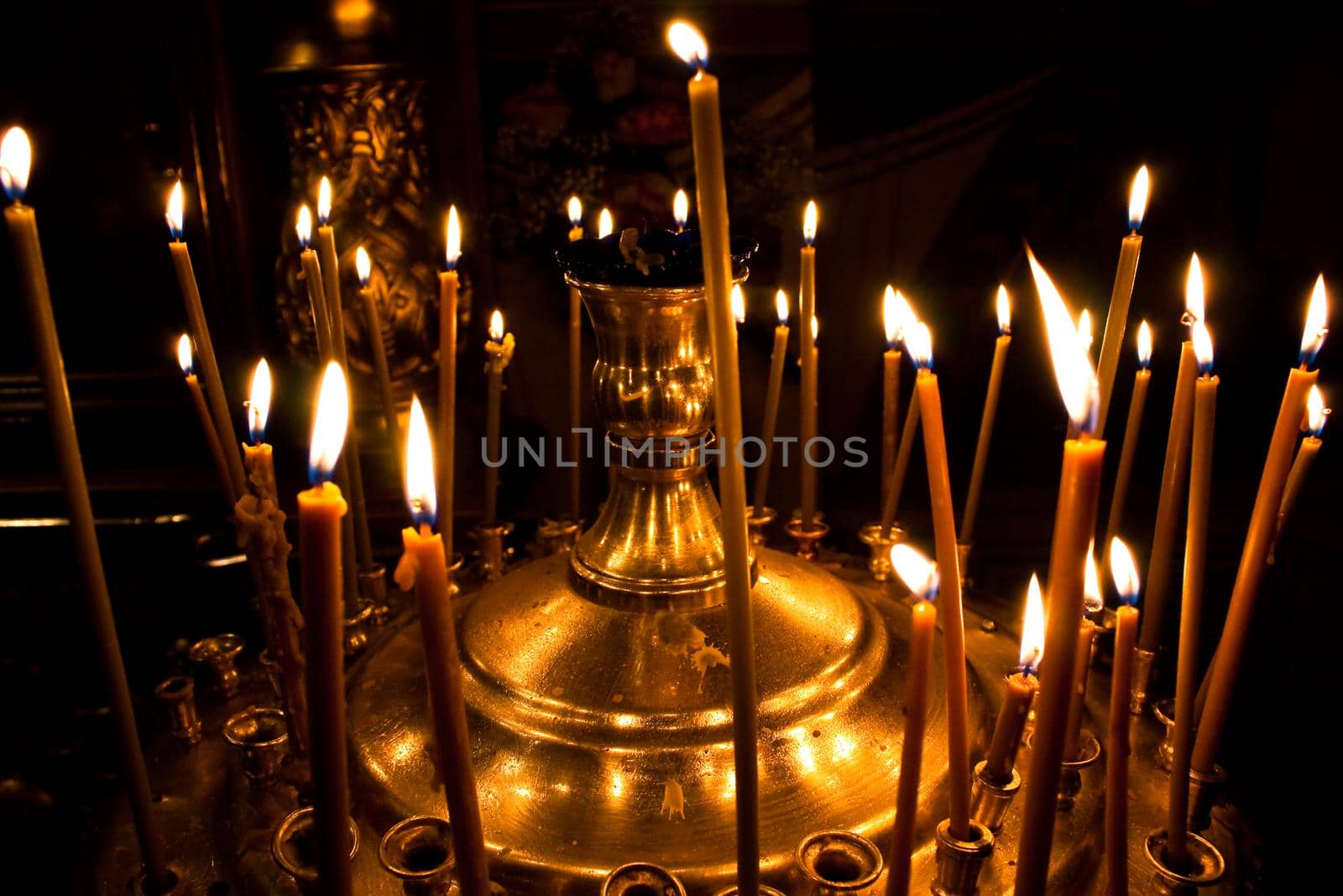 photo of burning candles in church with dark background