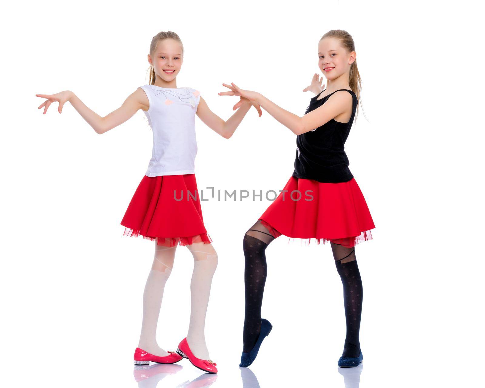Two cheerful little girls are dancing. by kolesnikov_studio
