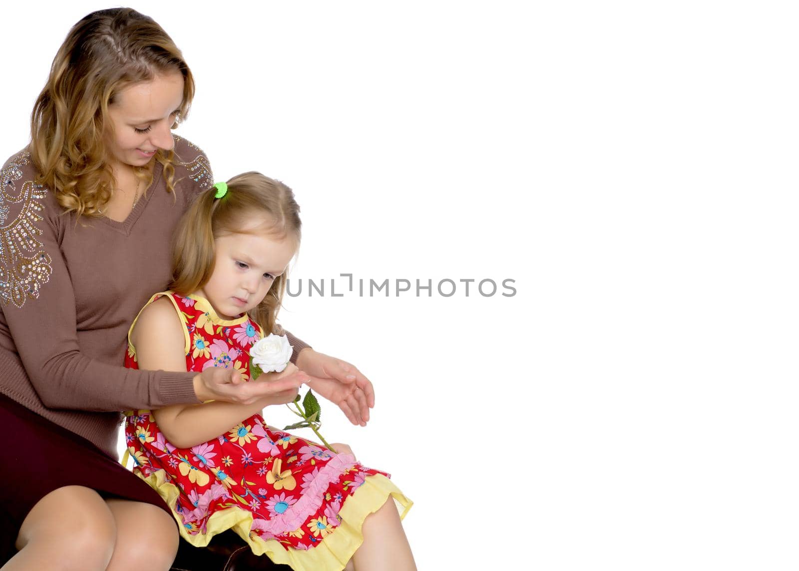 Young mother and little daughter gently embrace. The concept of Happy Childhood, Family Happiness, Raising a Child. Isolated on white background.