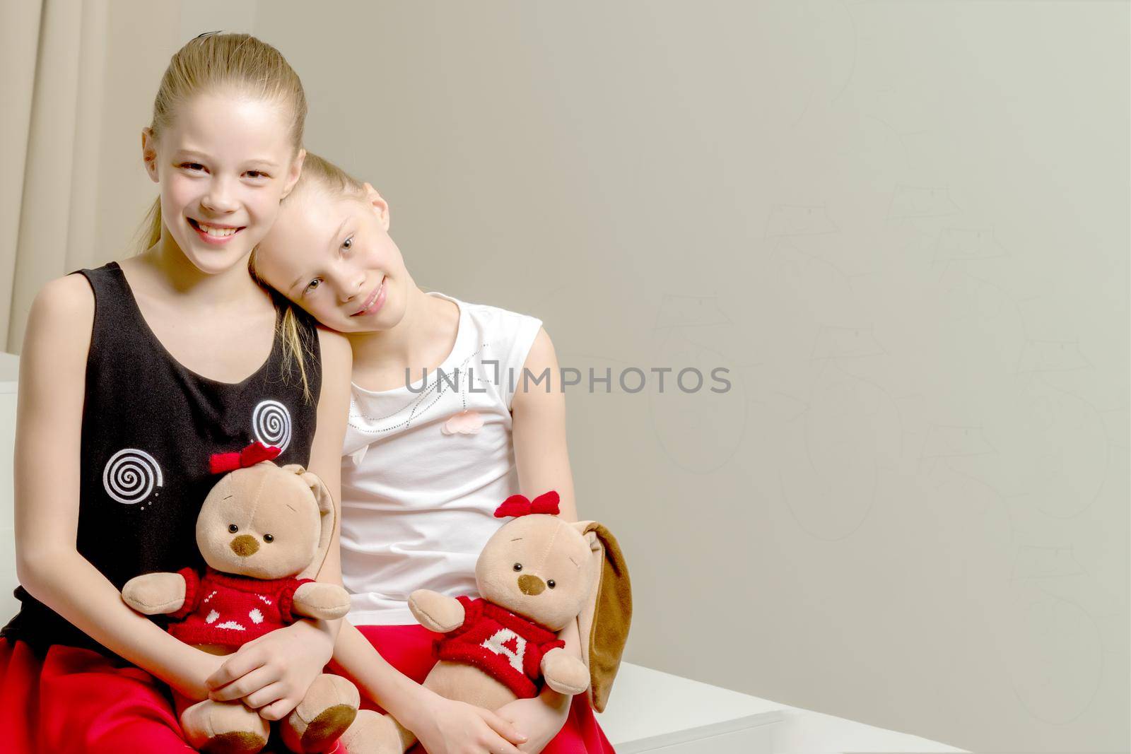 Two cute little girls close-up, in the studio. The concept of a happy childhood, Beauty and fashion.