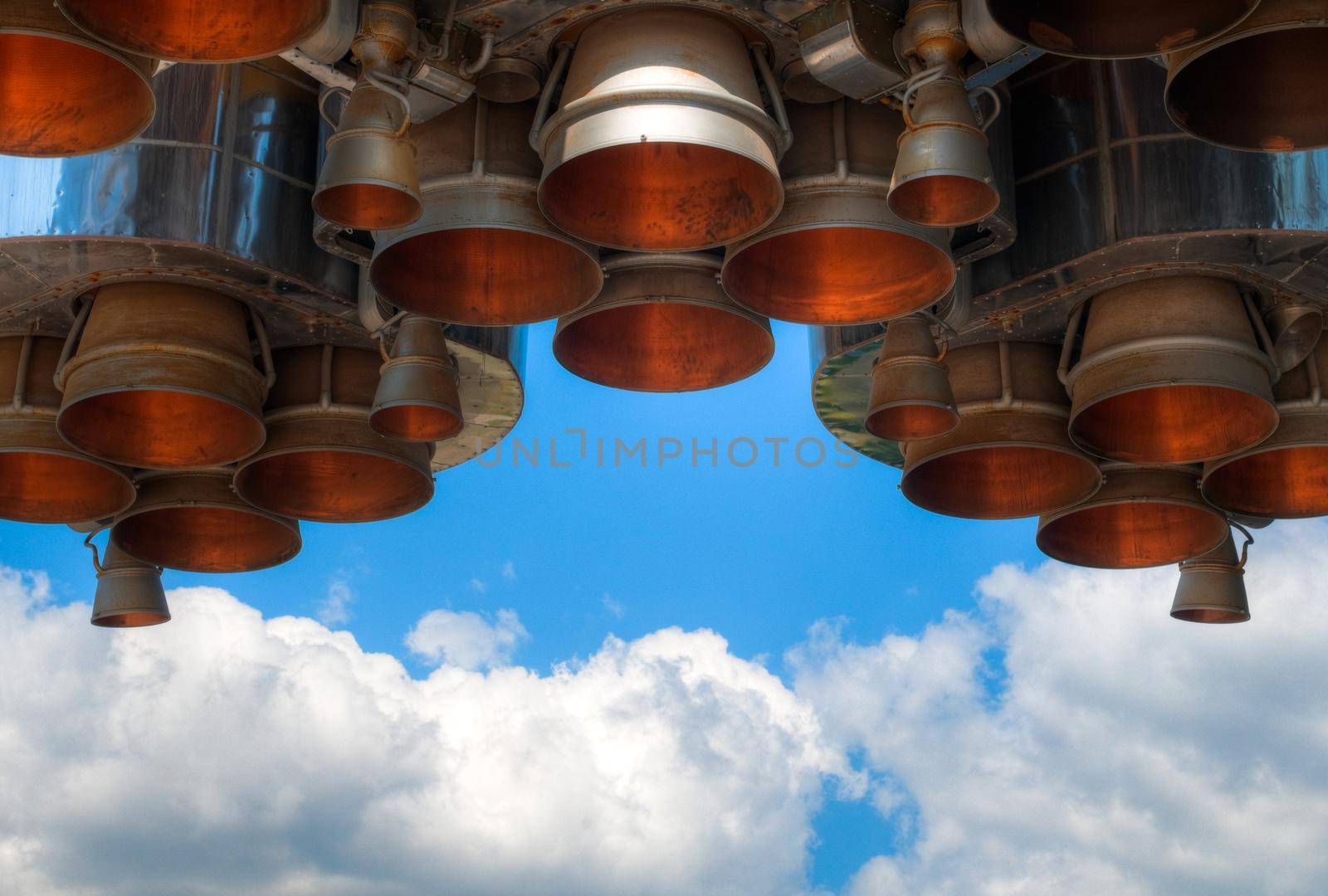 details of space rocket engine against blue sky with clouds