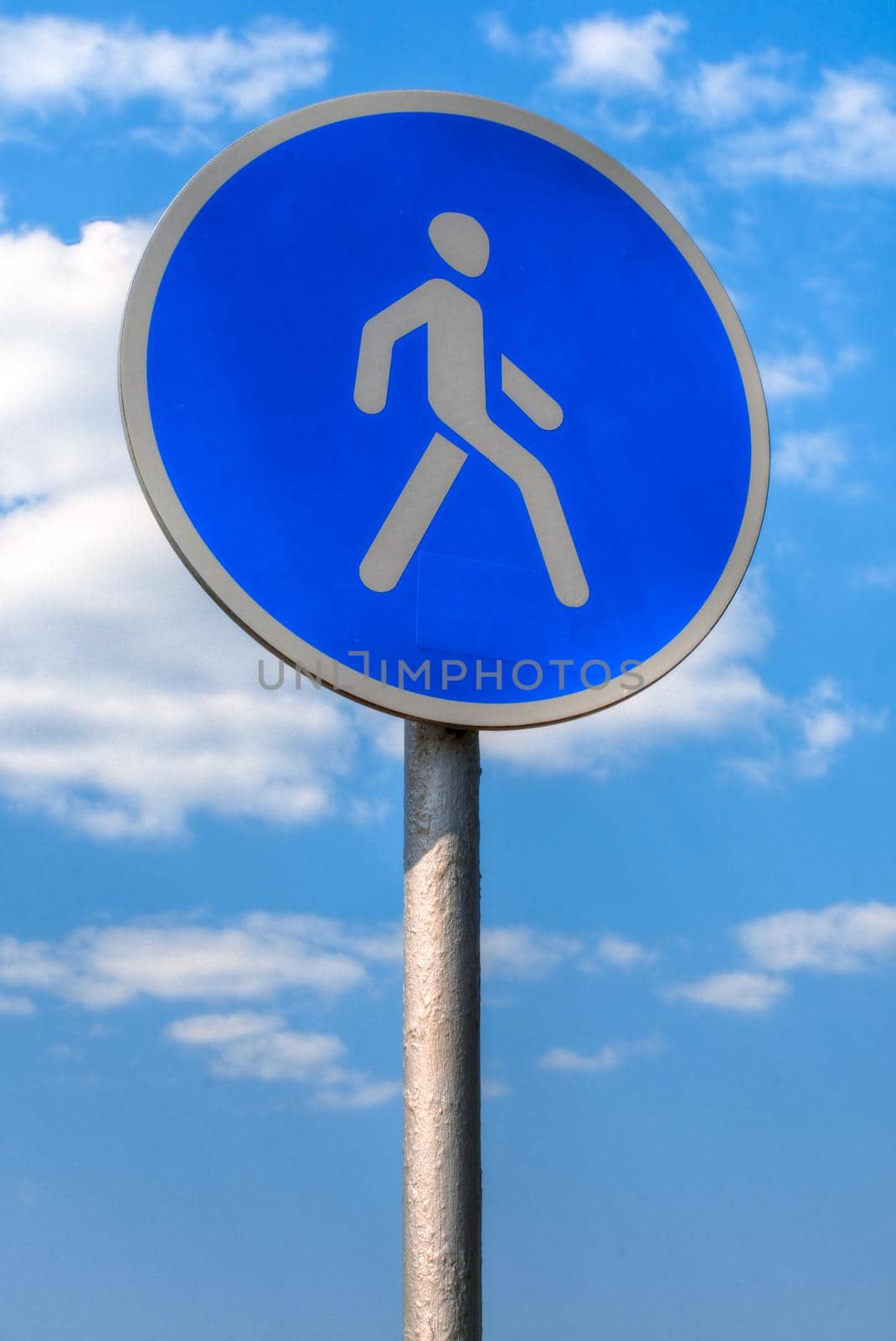 pedestrian zone sign against blue sky with clouds