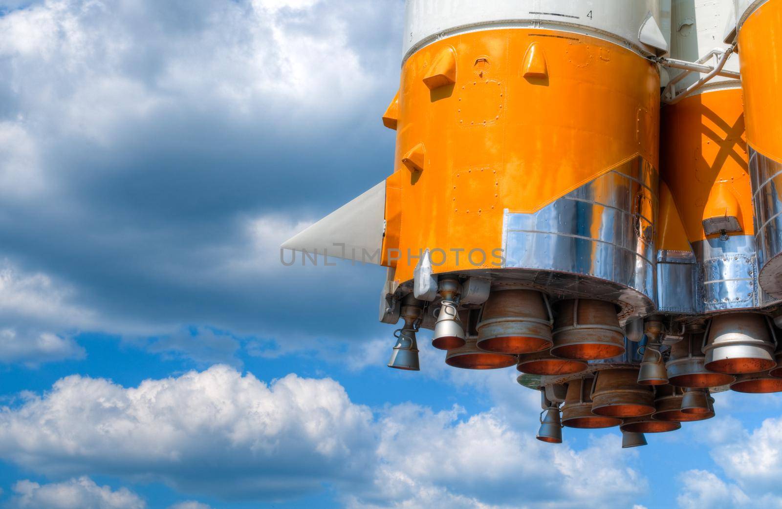 details of space rocket engine against blue sky with clouds