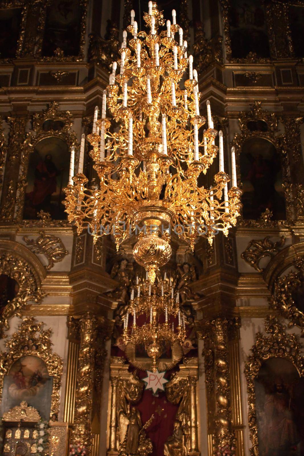 photo of iconostasis with chandelier in foreground in russian church