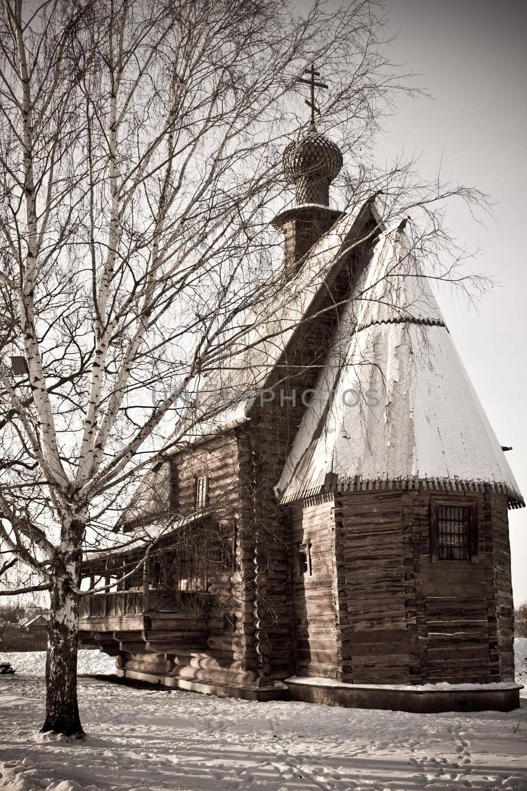 old wooden church in the birch tree forest in the winter