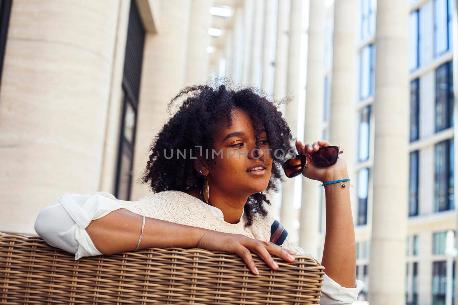 young pretty african girl posing cheerful on city background, lifestyle outdoor people concept close up