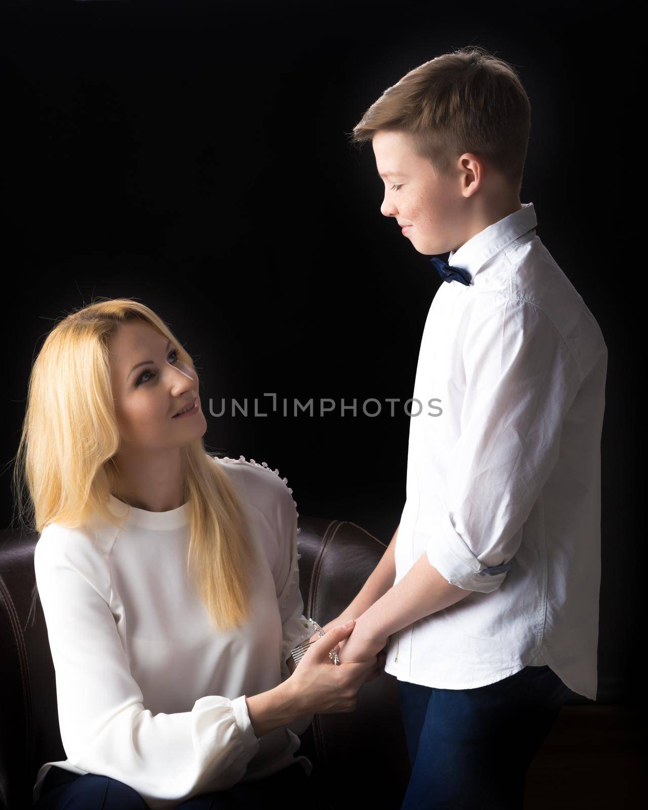 Mom and son teenager on a black background. by kolesnikov_studio