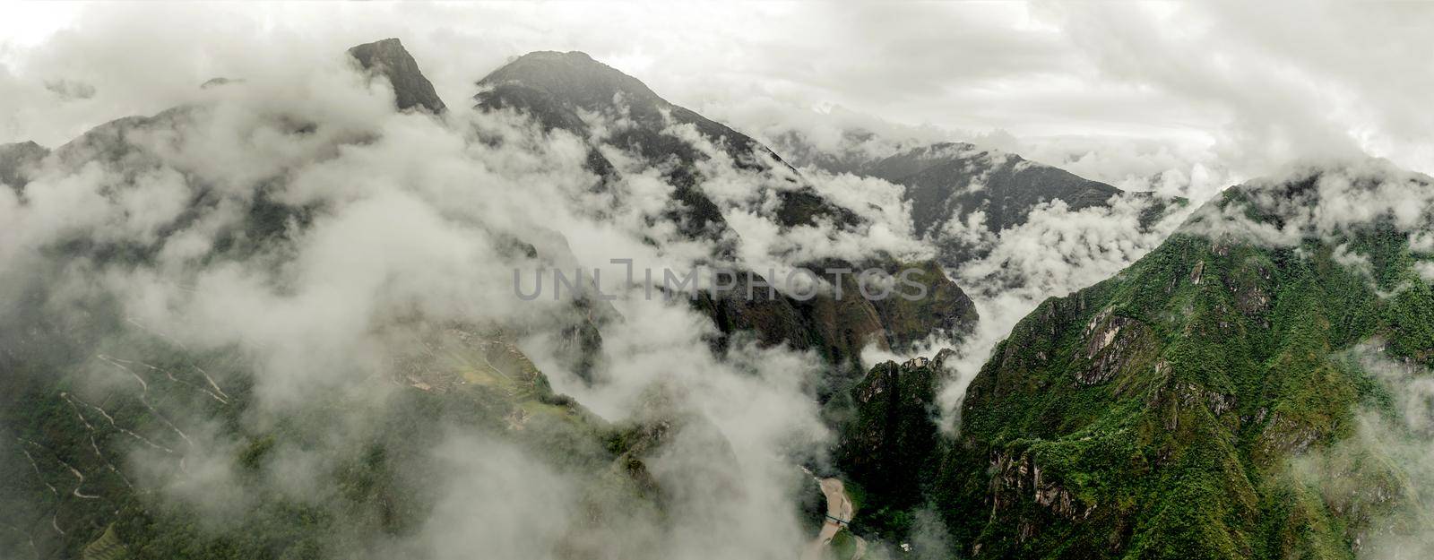 Majestic Machupicchu forested and covered with clouds, aerial view