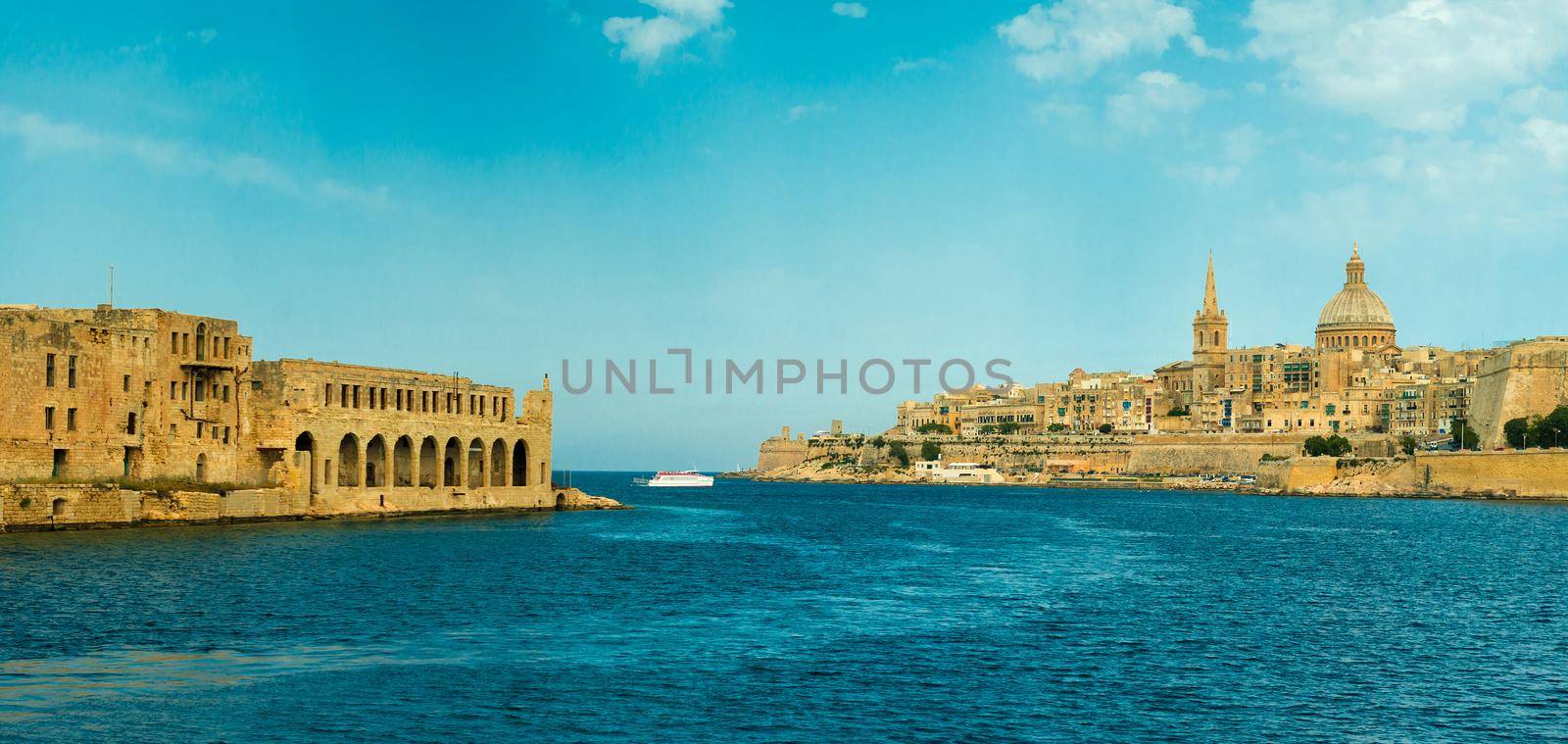 panoramic view of Valletta and wall of fortress with arches from sea, Malta