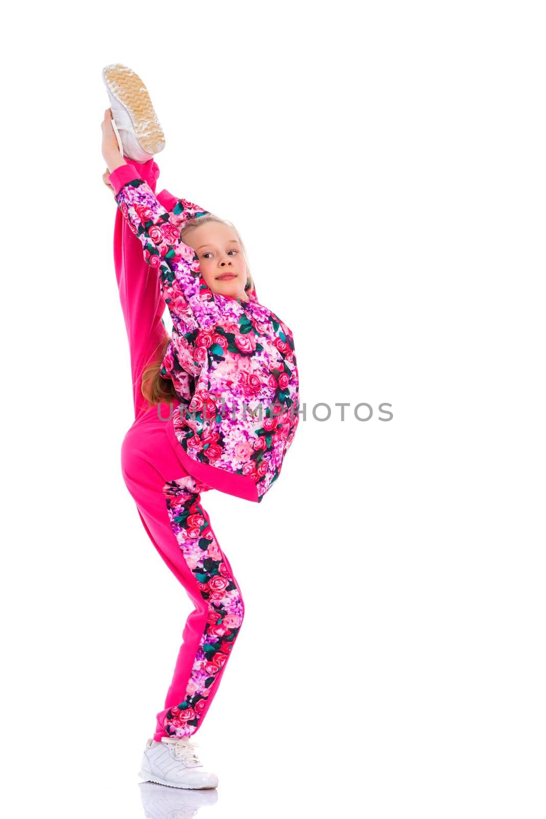 A girl gymnast balances on one leg.The concept of childhood, sport, a healthy lifestyle. Isolated on white background.