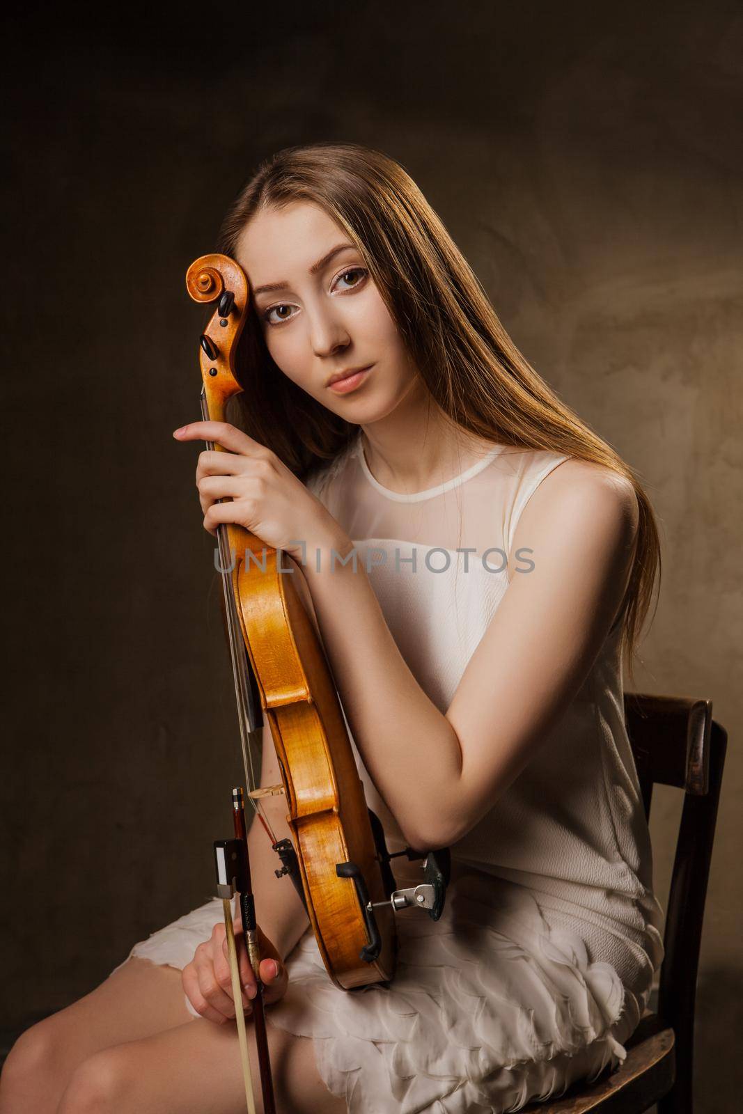 Beautiful young woman playing violin over black by Julenochek