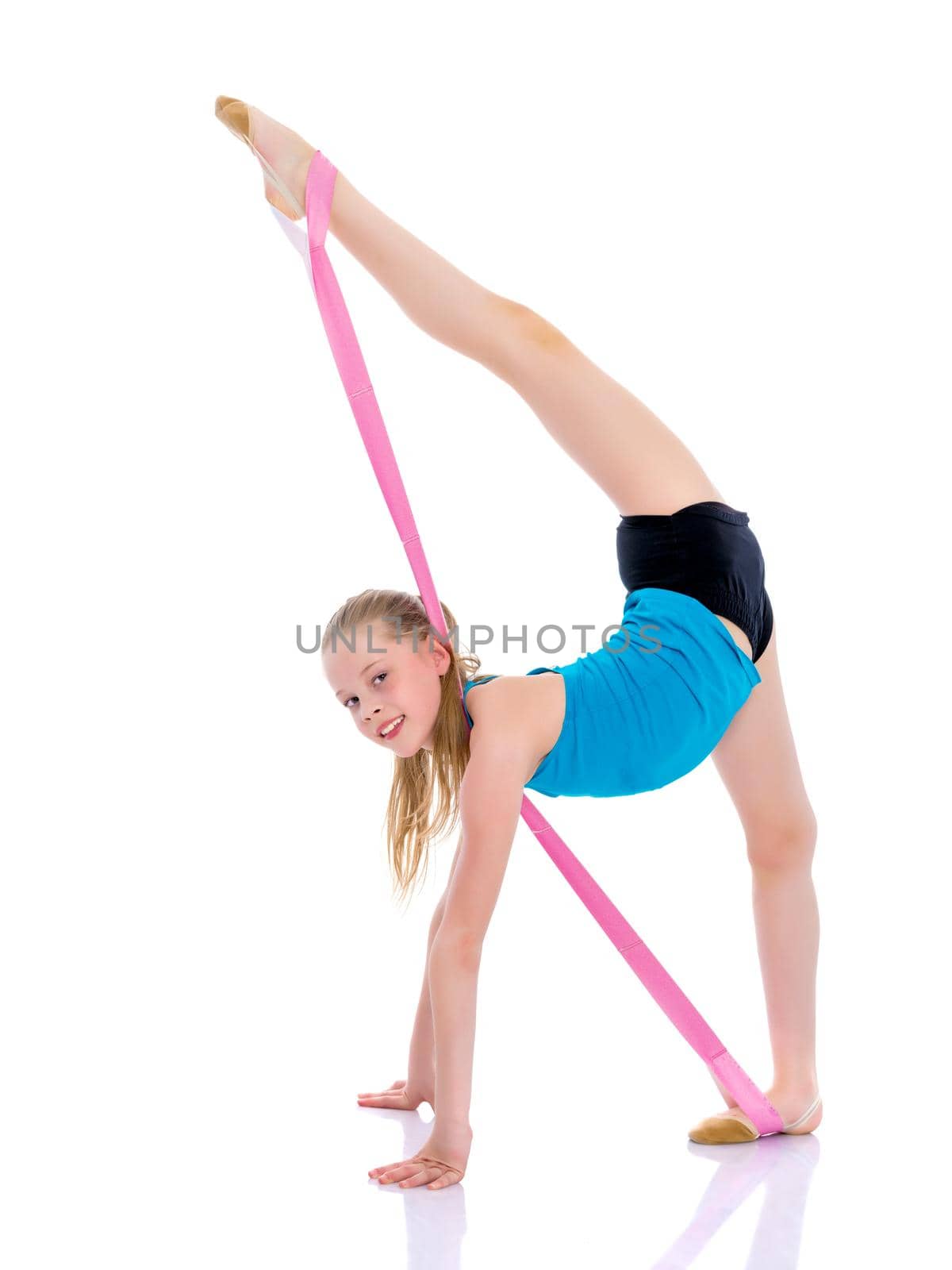 A girl gymnast performs an acrobatic element on the floor. The concept of childhood, sport, healthy lifestyle. Isolated on white background.