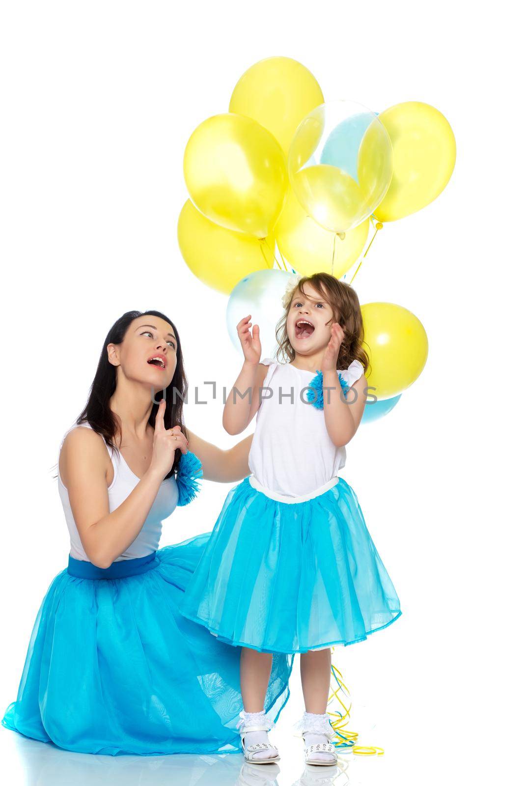 Beautiful mother and daughter in long blue skirts, along with balloons.They rejoice in the holiday.Isolated on white background.