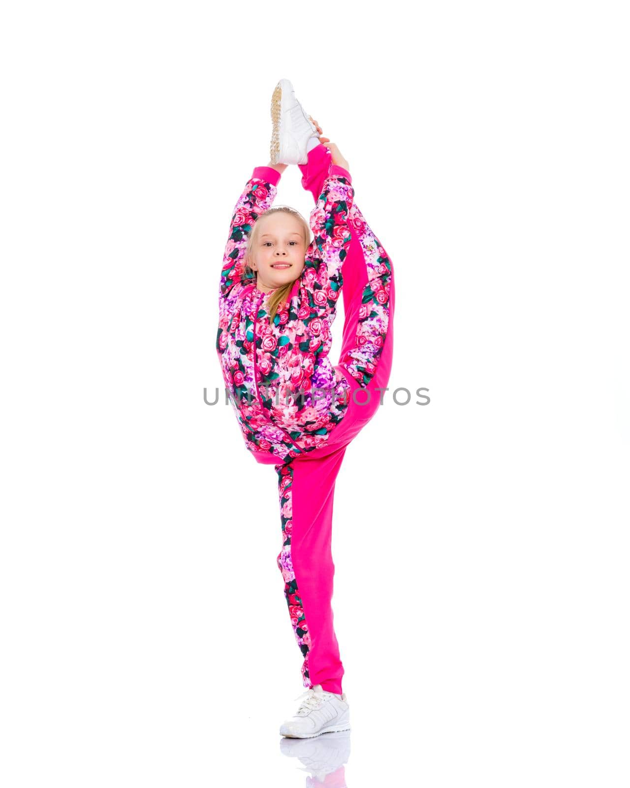 A girl gymnast balances on one leg.The concept of childhood, sport, a healthy lifestyle. Isolated on white background.