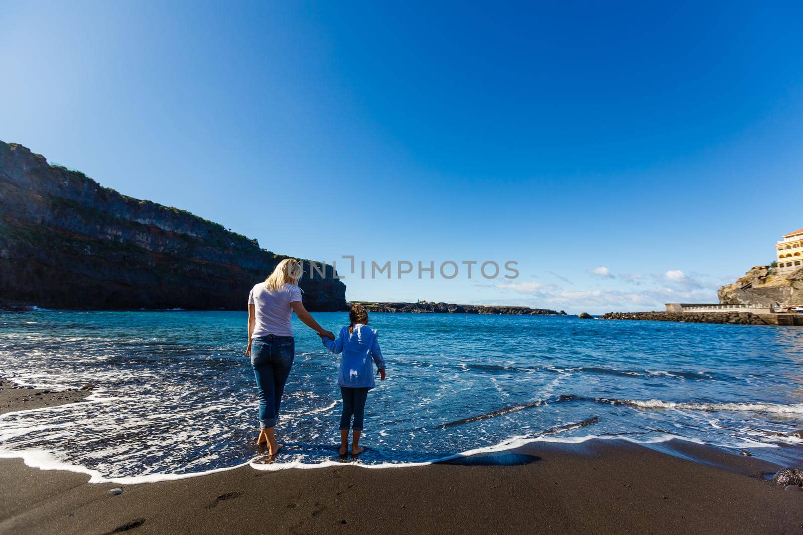 Family holiday on Tenerife, Spain. Mother with children outdoors on ocean. Portrait travel tourists - mom with kids. Positive human emotions, active lifestyles. Happy young family on sea beach