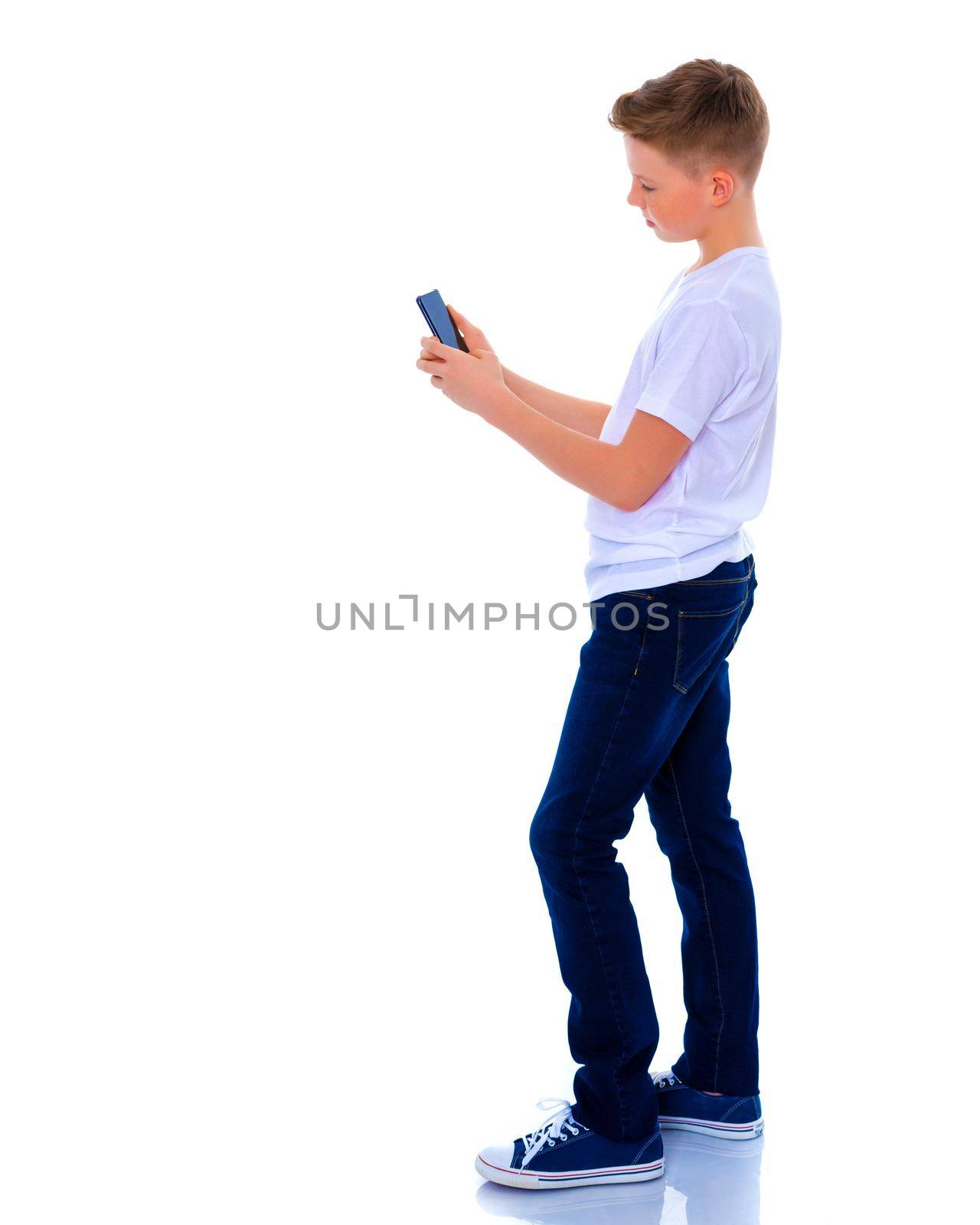 A little boy uses a mobile phone. by kolesnikov_studio