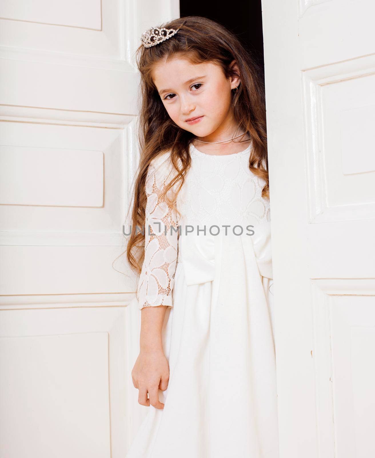 little cute girl at home, opening door well-dressed in white dress, adorable milk fairy teeth, curious child