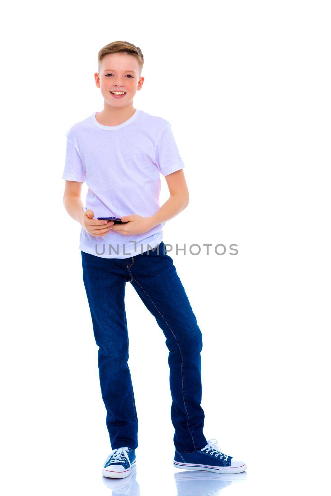 A small boy of school age uses a mobile phone. The concept of digital technology, communication between people. Isolated on white background.