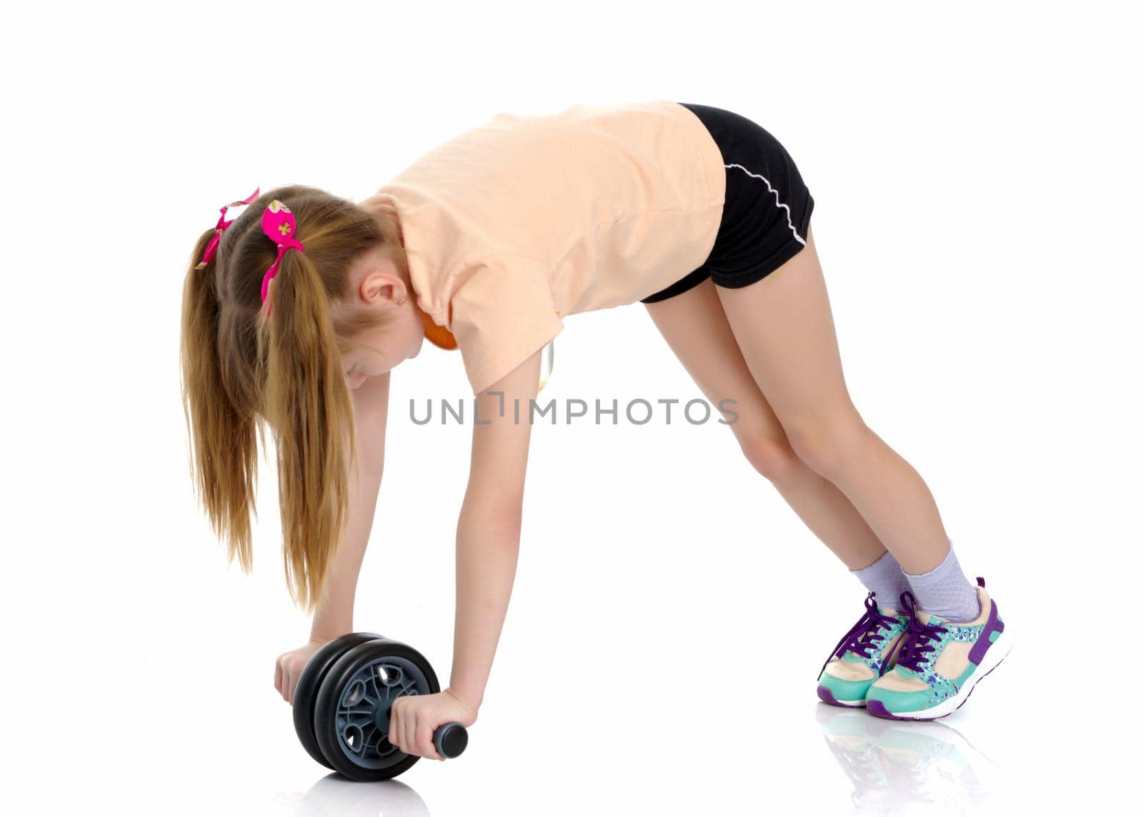 A nice little girl is performing gymnastic exercises. Concept of a healthy lifestyle, sport and fitness. Isolated on white background.