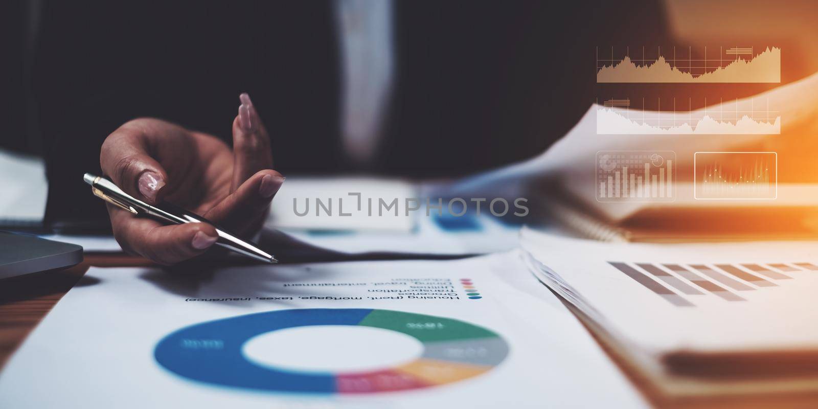 Close up Business woman hand holding pen and pointing at financial paperwork with financial network diagram.