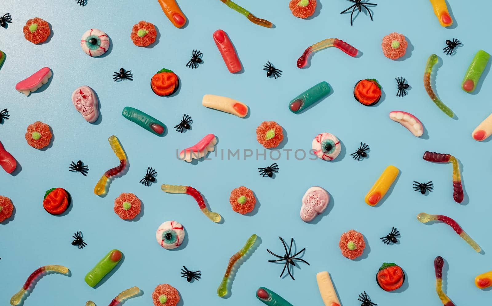 Halloween concept. Colorful sweets for Halloween party on blue background, top view flat lay