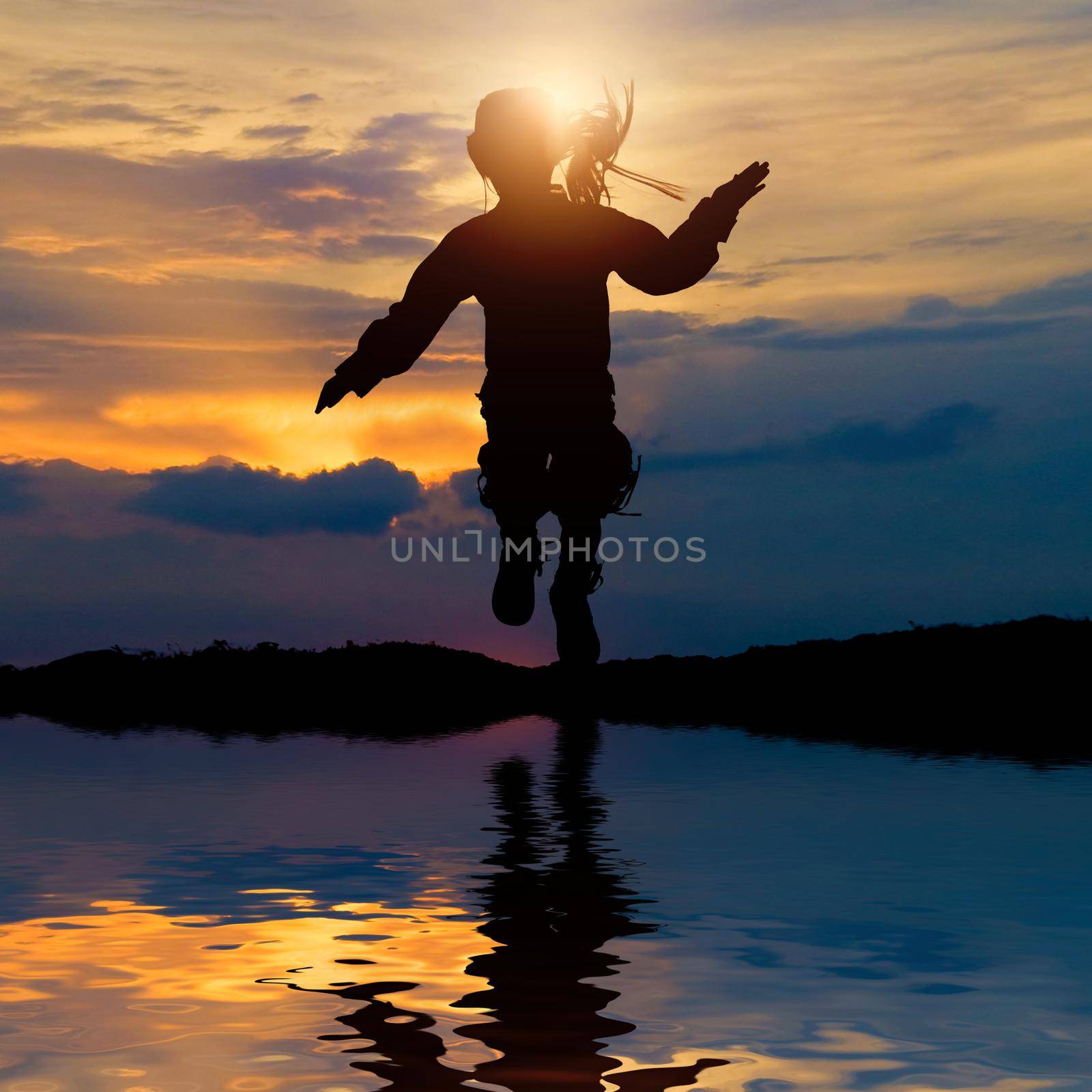 silhouette of a girl jumping on a background of the sea at sunset