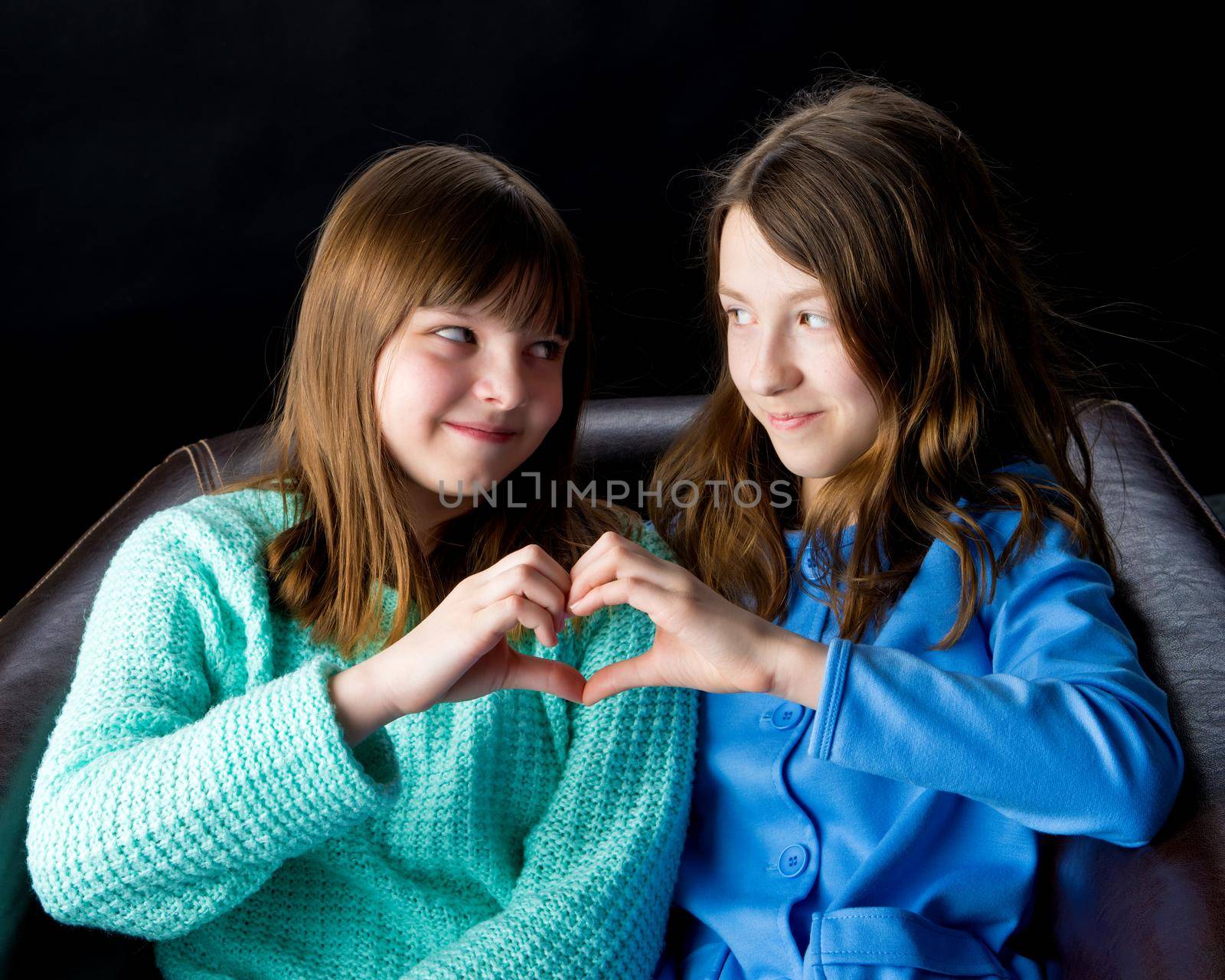 Two girls folded their palms in the form of a heart. by kolesnikov_studio