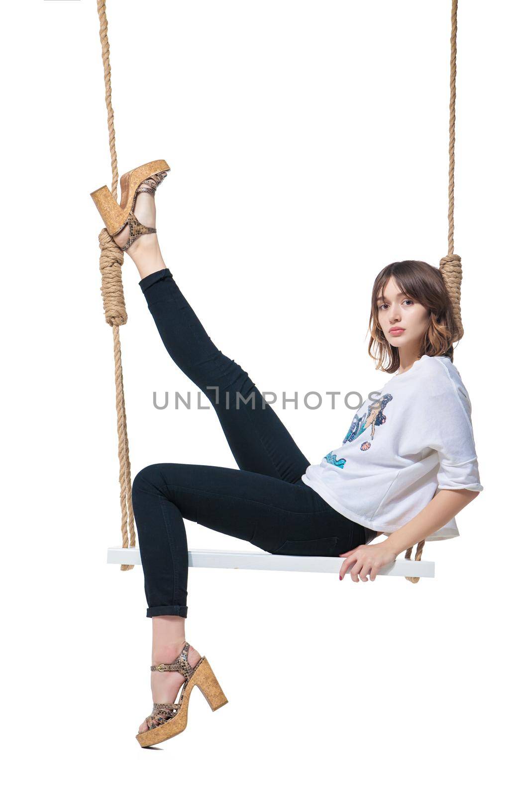 Beautiful girl swinging on swing. Isolated by Julenochek