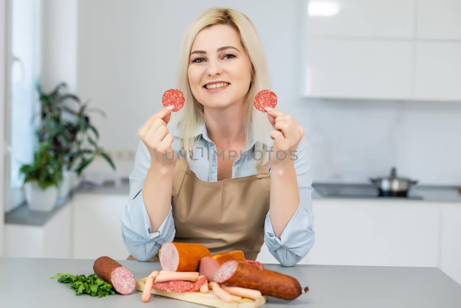 The girl is eating sausage. A piece of sausage. Smile and Joy. Business concept is the brand's appeal. Appetite