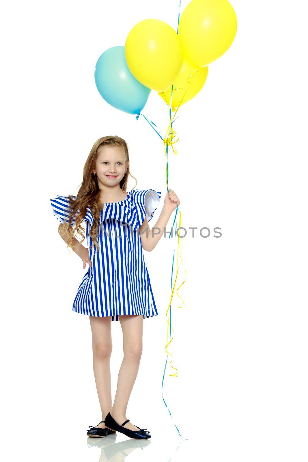 Adorable little blond girl in very short summer striped dress.She holds multicolored balloons in her hand.Isolated on white background.