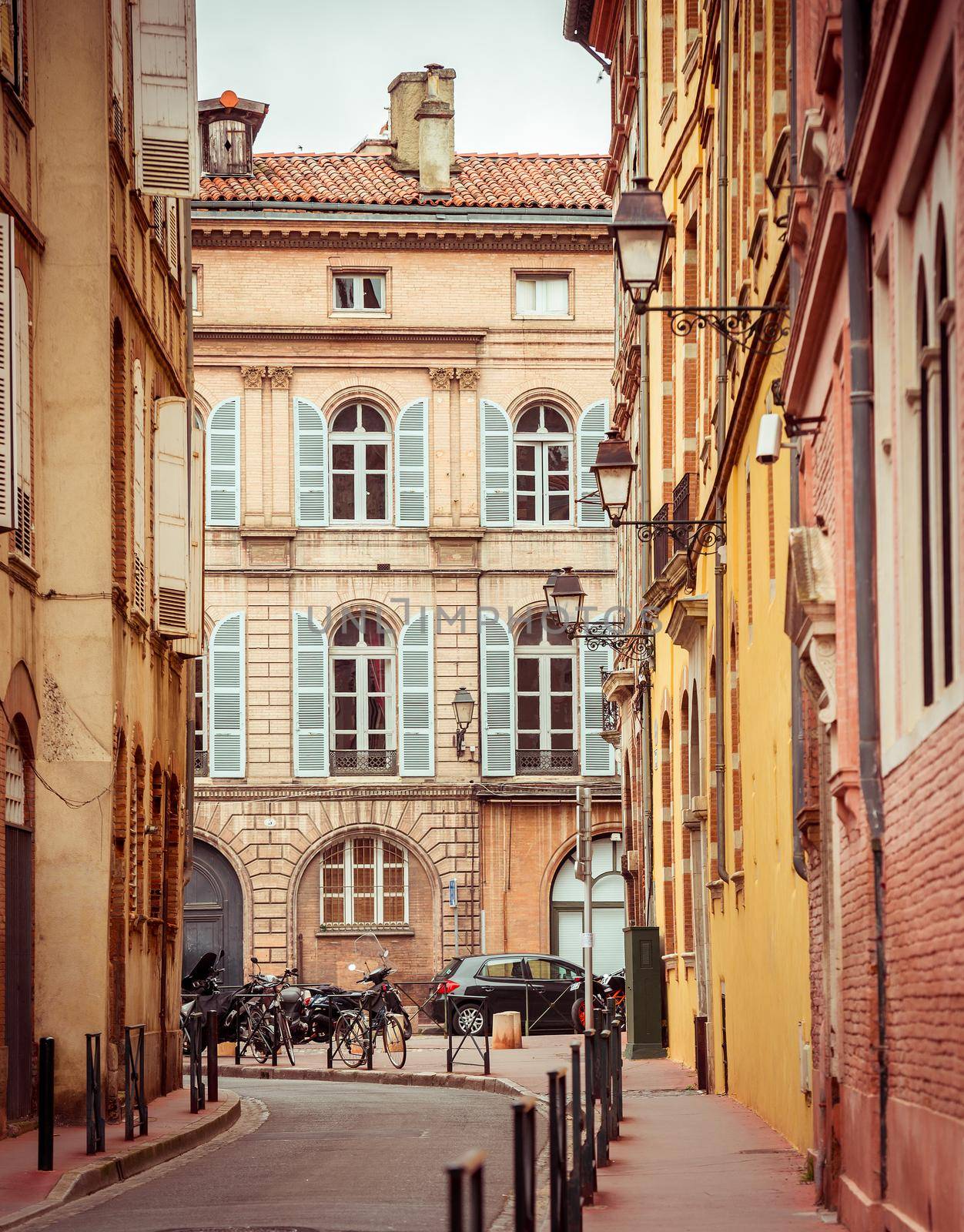Narrow historic street with old buildings in Toulouse, France