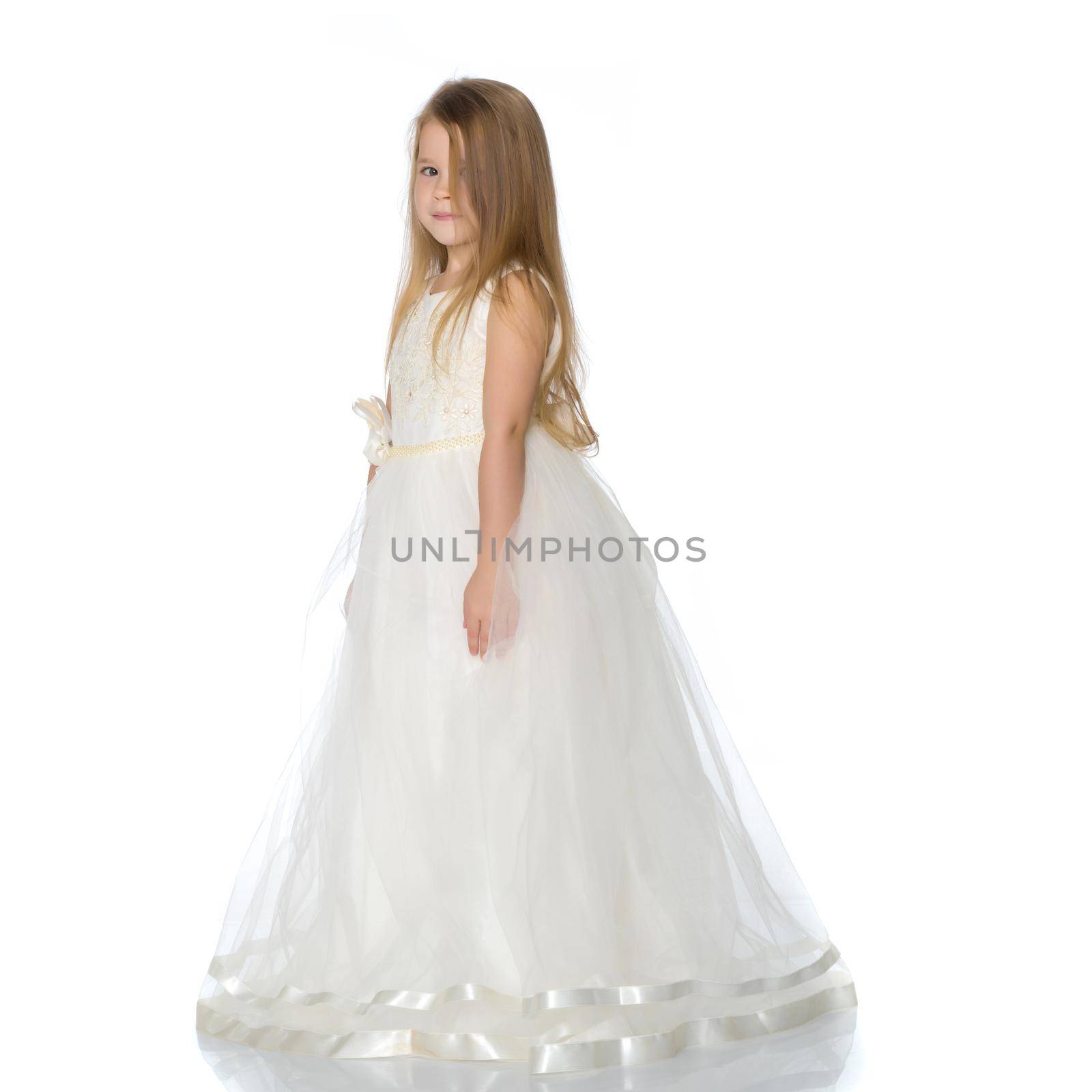 Charming little princess in a long dress. The concept of a happy childhood, beauty and fashion. Isolated on white background.