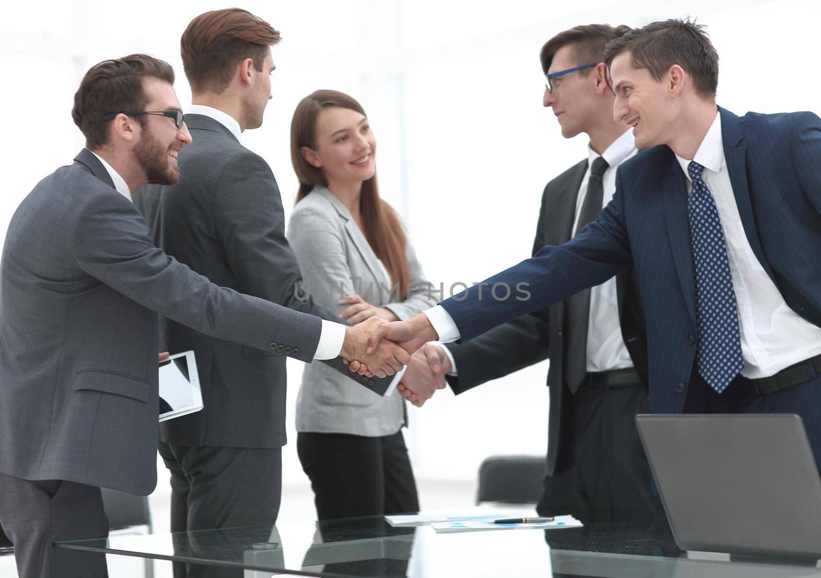 leaders of business teams shake hands.